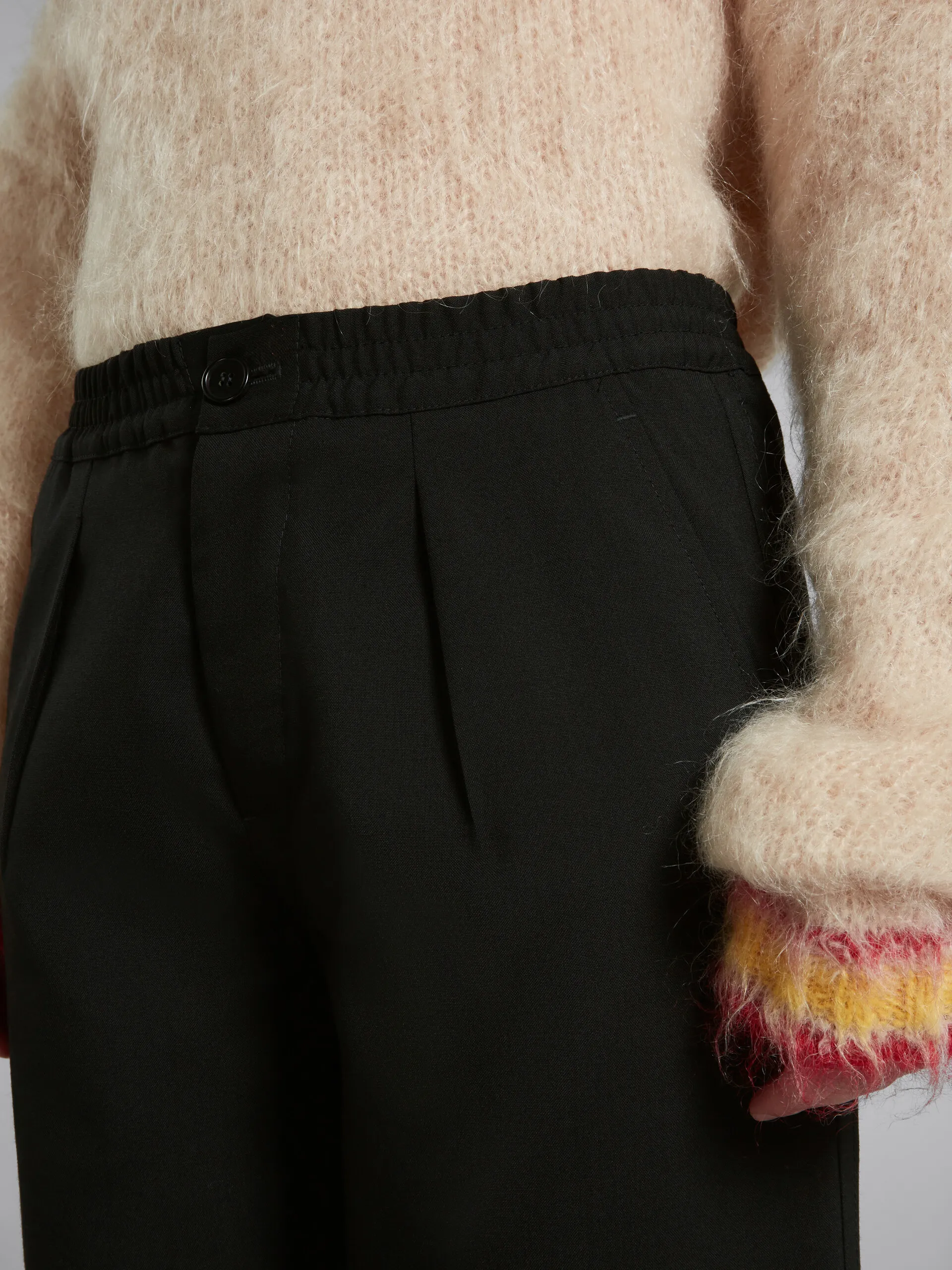 Pantaloni in lana nera con pieghe sul davanti